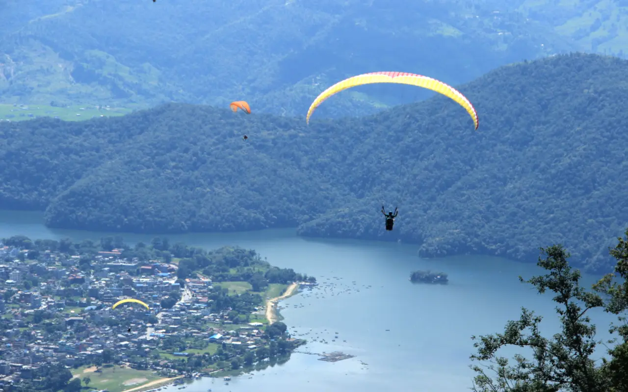 A breathtaking view of a paraglider soaring over Pokhara.